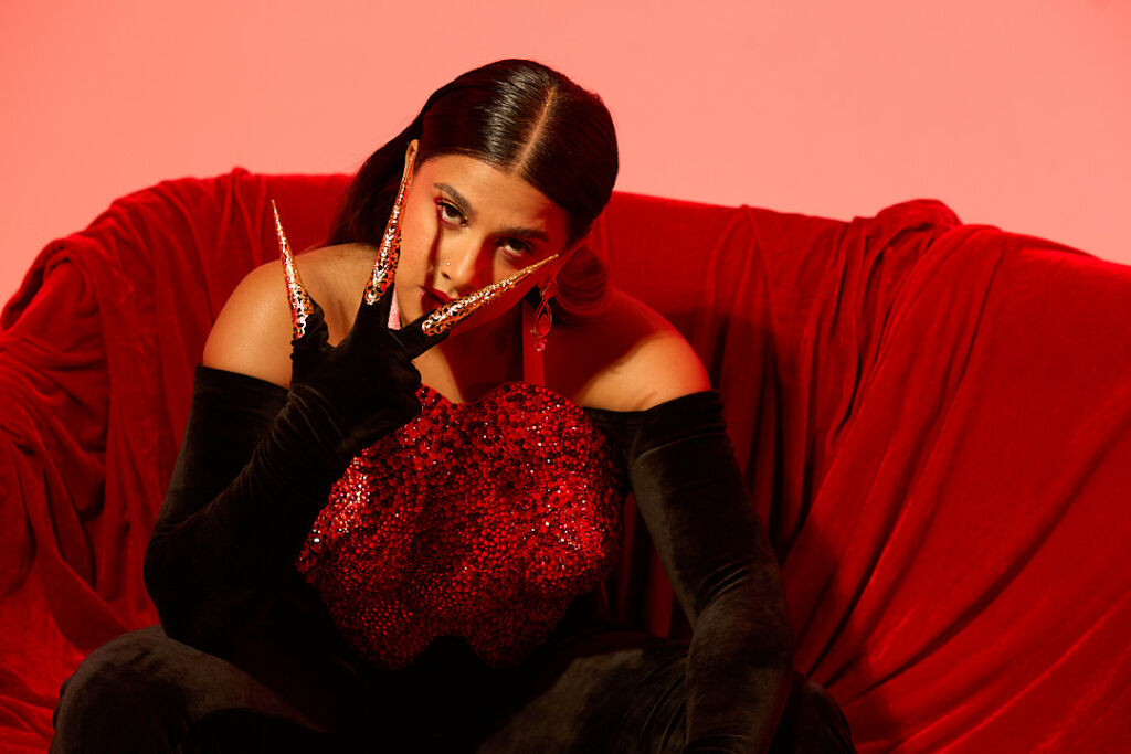 Tracy De Sa sur un canapé rouge